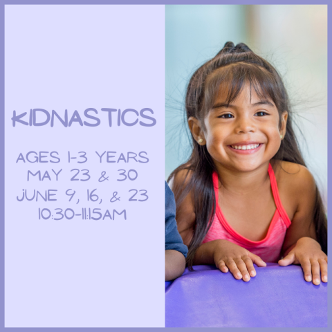 A child leaning over a obstacle piece, smiling.